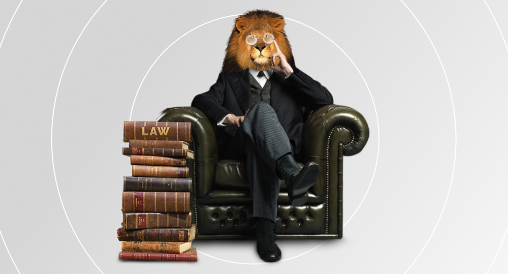 Lion in pince-nez with tie sits next to stack of law books